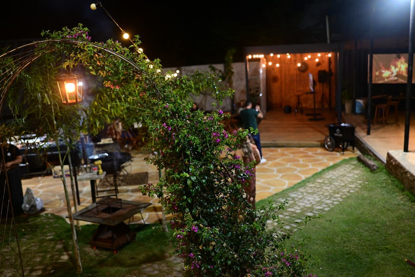 Jardim com arco florido e luminária